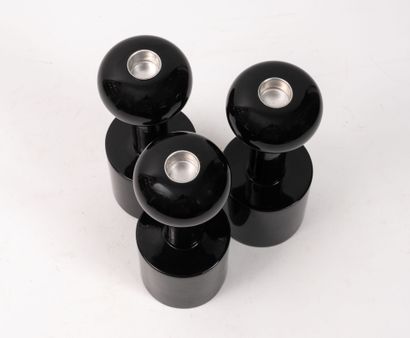 Three black-lacquered turned-wood torches...
