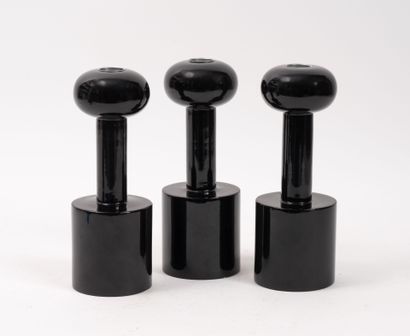 Three black-lacquered turned-wood torches...
