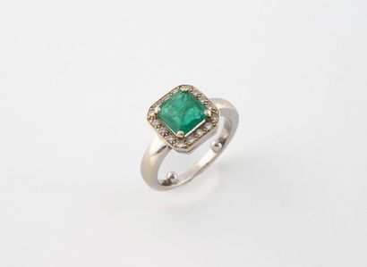 A white gold (750) ring centered on an emerald-cut...