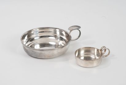 Two circular silver-plated wine tasters.
-...