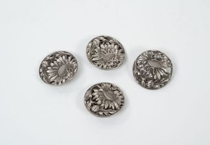 Quatre grands boutons à décor de marguerites...