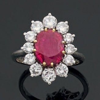 Bague en or gris ornée d'un rubis ovale entouré...