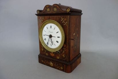 Pendule borne sur plinthe en placage de palissandre...