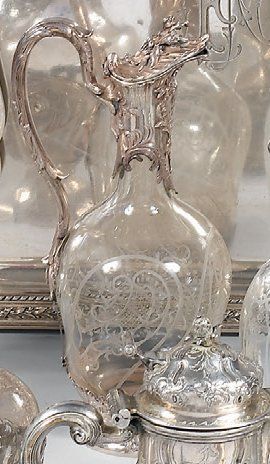 Carafe en cristal à pans. La monture en métal...