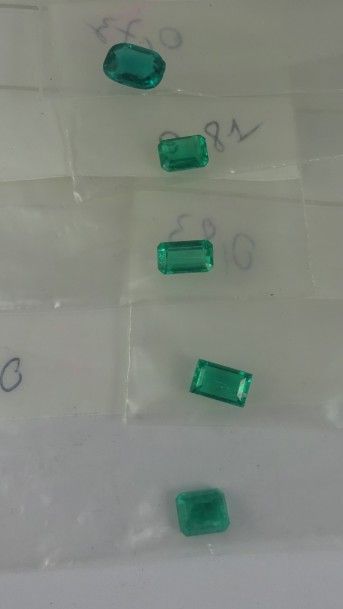 Lot de cinq émeraudes sur papier. 