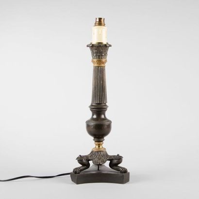 Lampe en métal patiné et doré reposant sur...