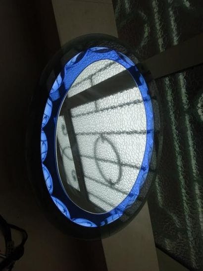 Miroir de forme ovale à fond en verre fumé...
