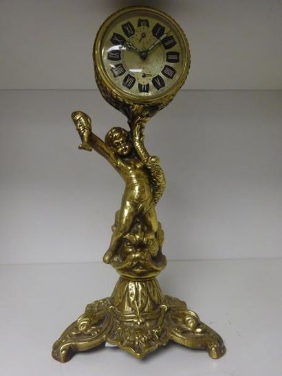 Pendulette en bronze doré soutenue par un...