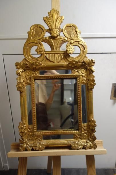 Miroir à fronton ajouré en bois et stuc doré.
XIXème...