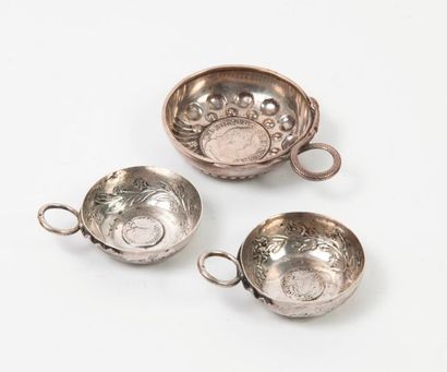Trois tastevins en argent (800) centrés d'une...