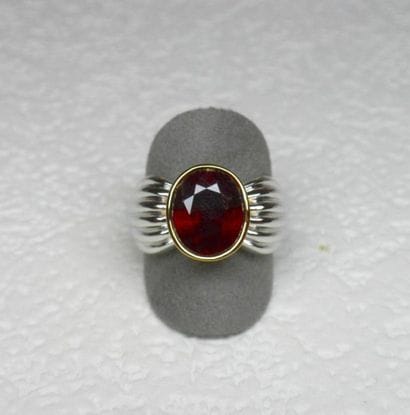Bague bicolore soutenant en clos un rubis...