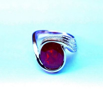 Bague en or blanc en clos d'un rubis ovale...