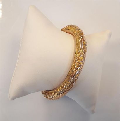 Bracelet rigide ouvrant en or ciselé de dragons....