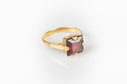Bague en or sertie d'un grenat carré (égrisures)....
