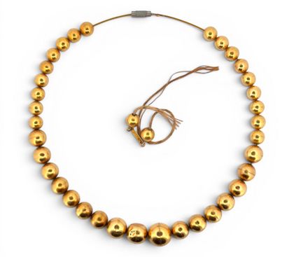 Cable en acier retenant des perles d'or 18K...