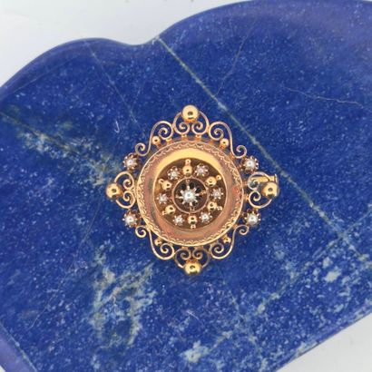 Broche en or jaune 18K (750) à décor de volutes...