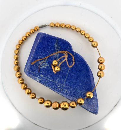 Cable en acier retenant des perles d'or 18K...