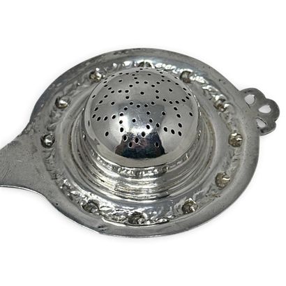 Silver (800) tea strainer with chased and...