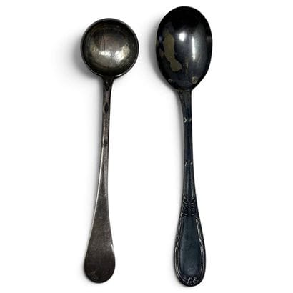 A small mustard spoon and a small silver...