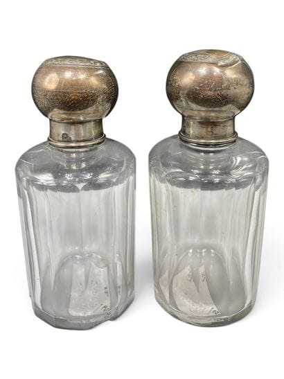 Pair of cylindrical glass bottles with beveled...