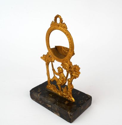 Porte-montre en métal doré figurant un putto...