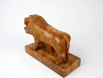 Lion rugissant en pierre sculptée reposant...