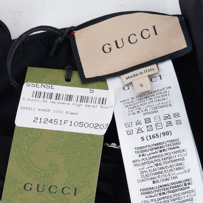 GUCCI
Maillot de bain noir. Une breloque...