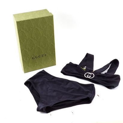 GUCCI
Maillot de bain noir. Une breloque...