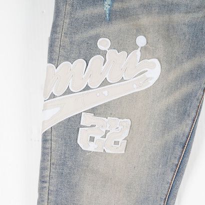 AMIRI
Jean bleu en denim délavé avec écusson...