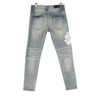 AMIRI
Jean bleu en denim délavé avec écusson...