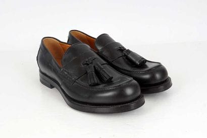 GUCCI 
Black leather loafers with a tasseled...