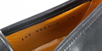GUCCI 
Black leather penny loafers adorned...