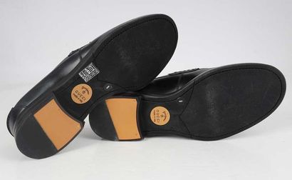 GUCCI 
Black leather loafers with a tasseled...