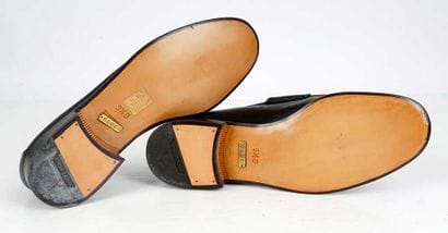 GUCCI 
Black leather penny loafers adorned...