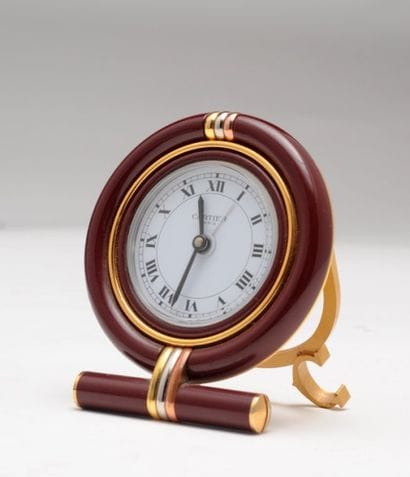 CARTIER
Réveil en métal doré et laque. Signé...