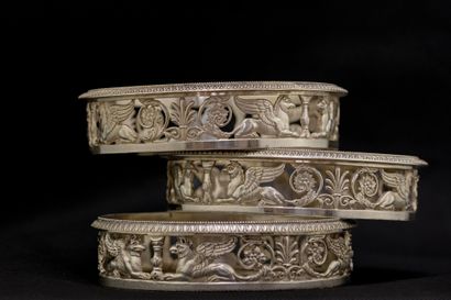 
SUITE OF THREE COASTERS. In chased silver,...
