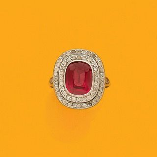 BAGUE
retenant en son centre une pierre rouge...