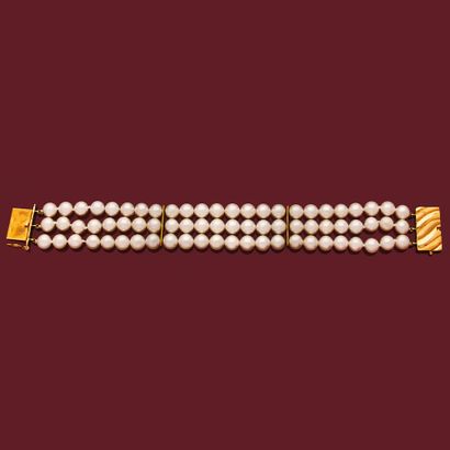 BRACELET
retenant trois rangs de perles blanches...