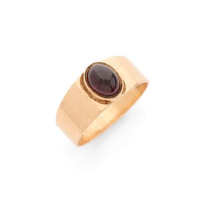BAND RING
set with an oval cabochon garnet....