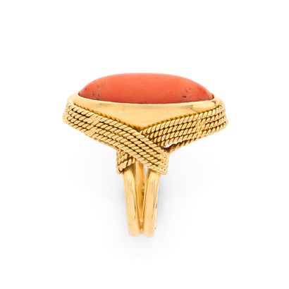 BAGUE
retenant un corail cabochon dans un...