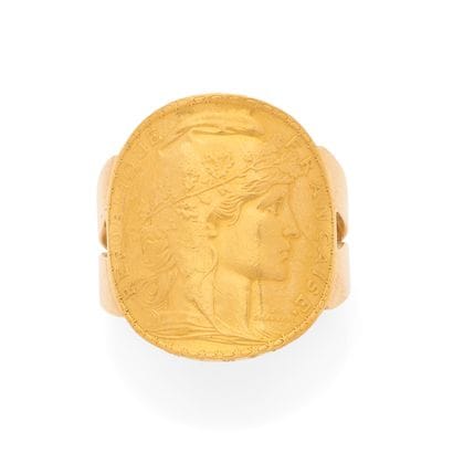 BAGUE
retenant une pièce de 20 francs or...