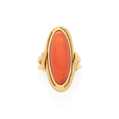 BAGUE
retenant un corail cabochon dans un...