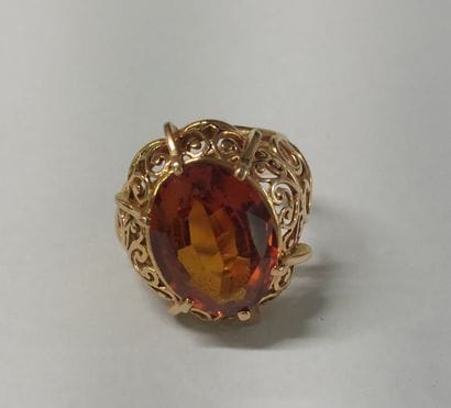 18K gold ring with an orange stone 

Size:...