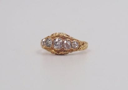 BAGUE en or jaune, la monture ciselée retenant...