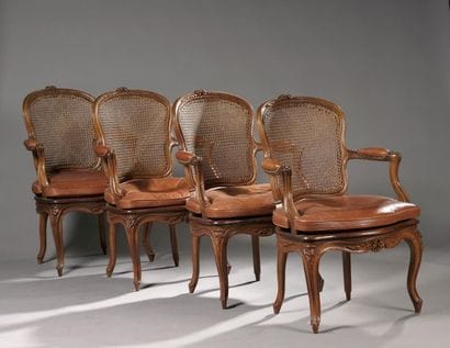 Suite de quatre fauteuils cannés en noyer...