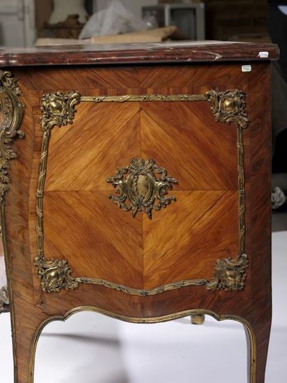 A curved chest of drawers with a slightly...