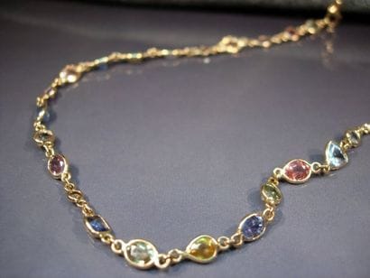 Collier en or jaune serti de saphirs multicolores...