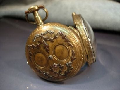 Montre oignon en laiton doré ornée de médaillons...