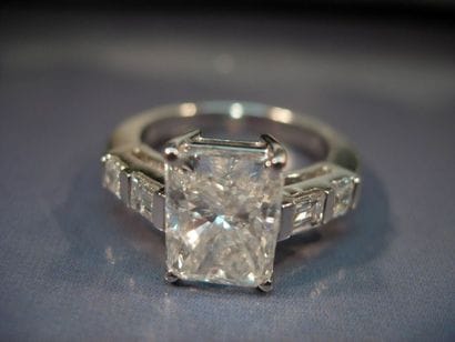 Bague en or gris centrée d'un diamant radian...
