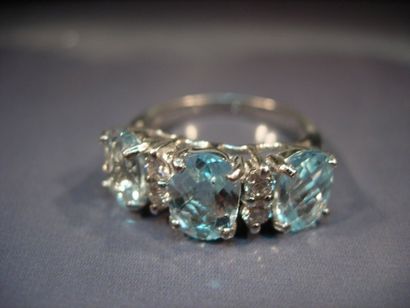 Bague en or gris sertie de trois topazes...